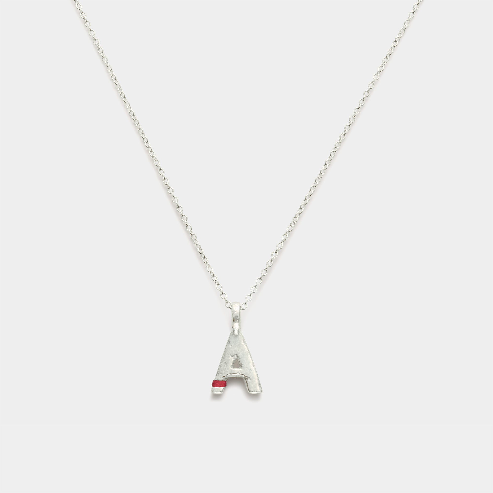 Silver necklace with a letter 'A' pendant on a white background