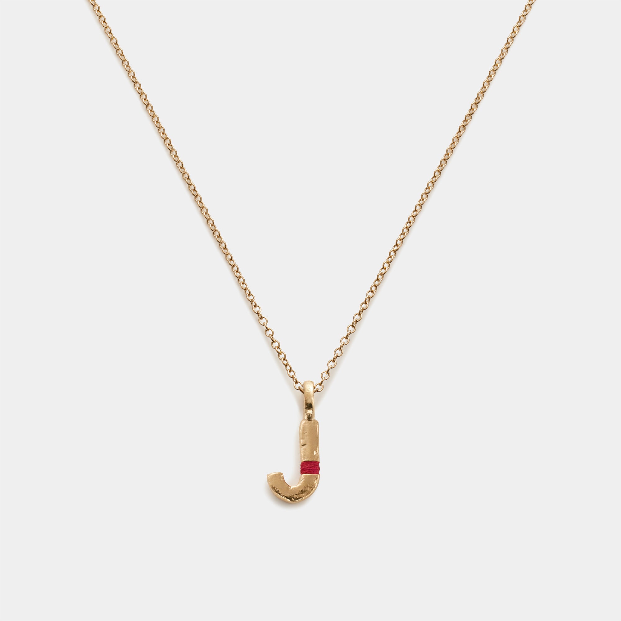 Gold necklace with a letter 'J' pendant.