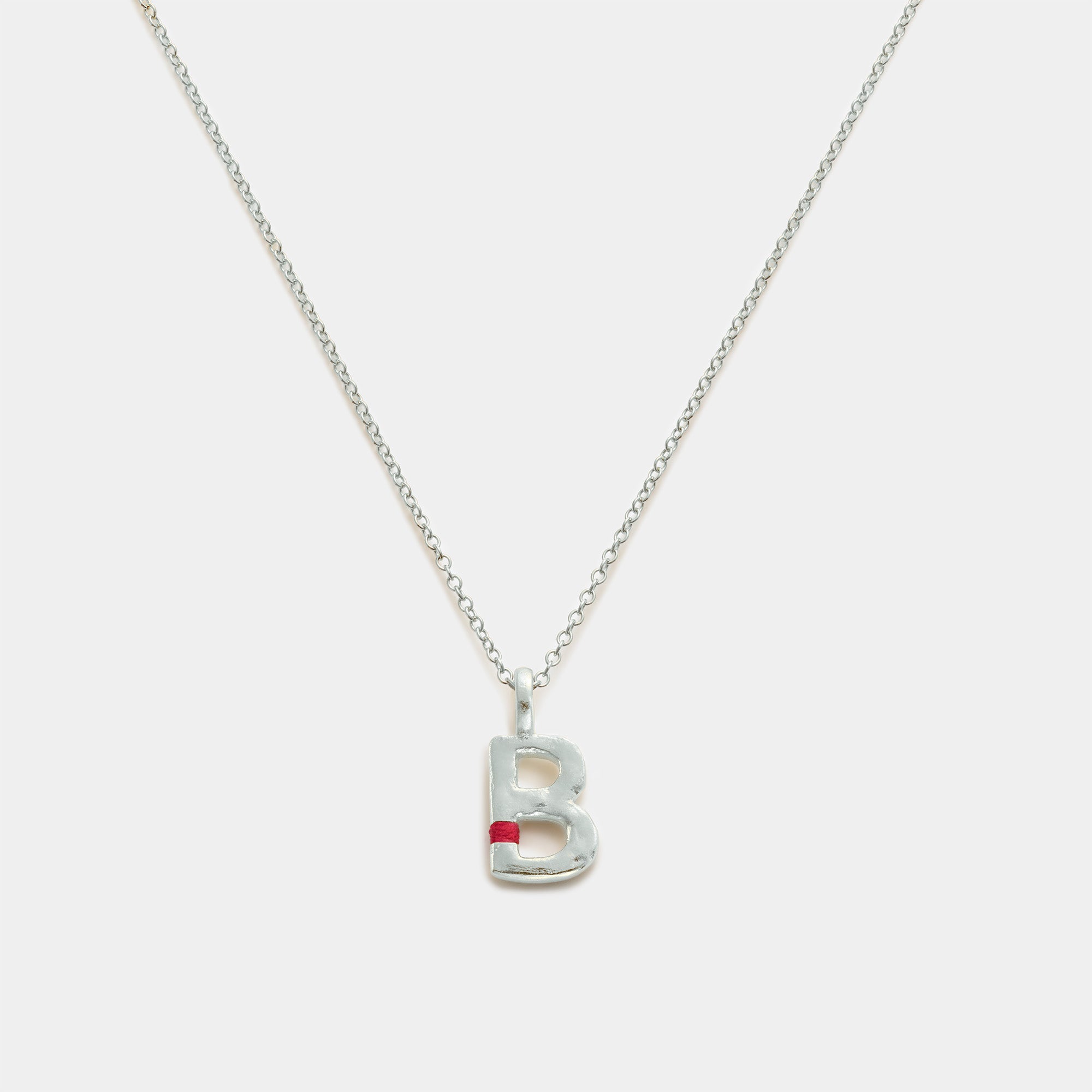 Silver necklace with a 'B' pendant on a white background
