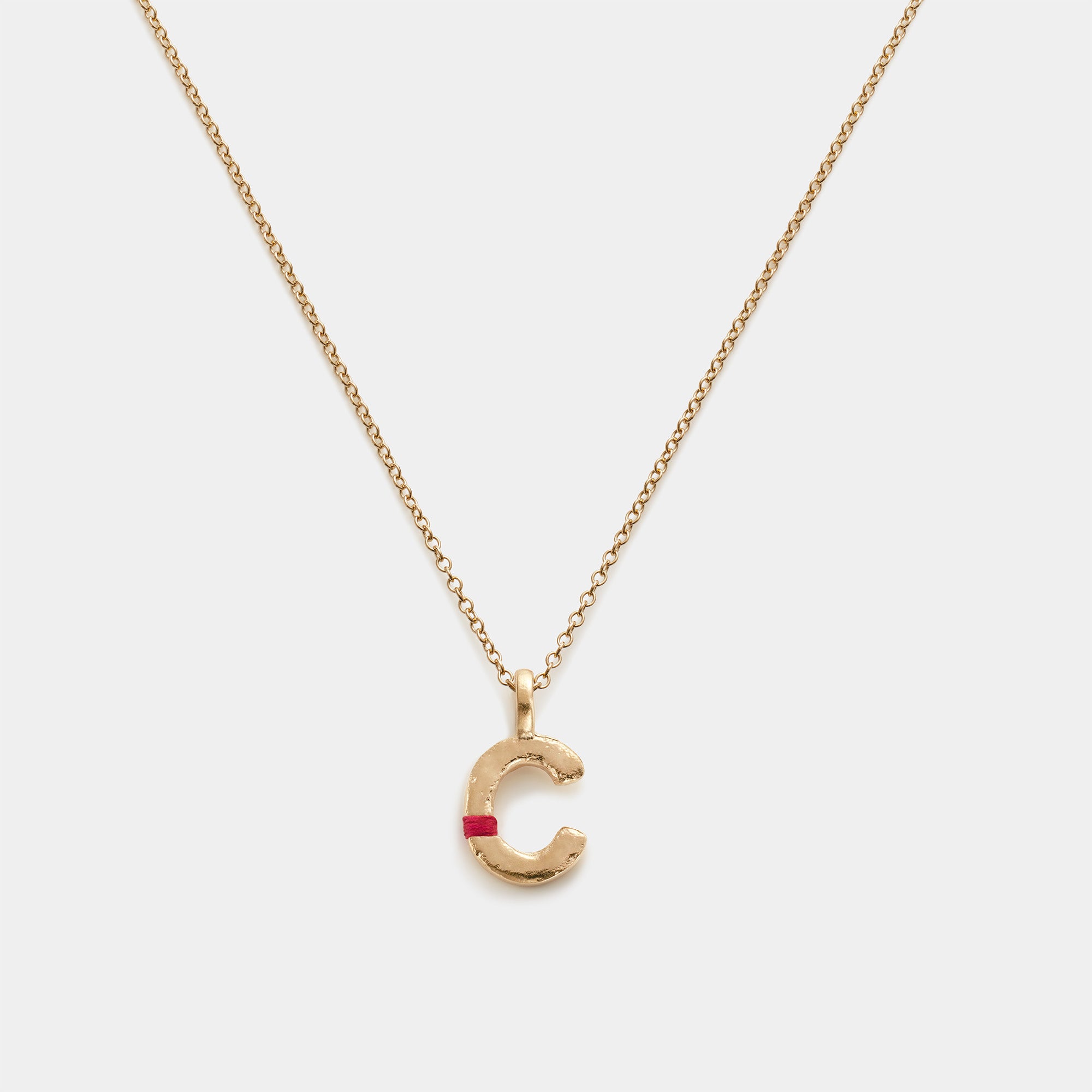 Gold necklace with a 'C' pendant on a white background