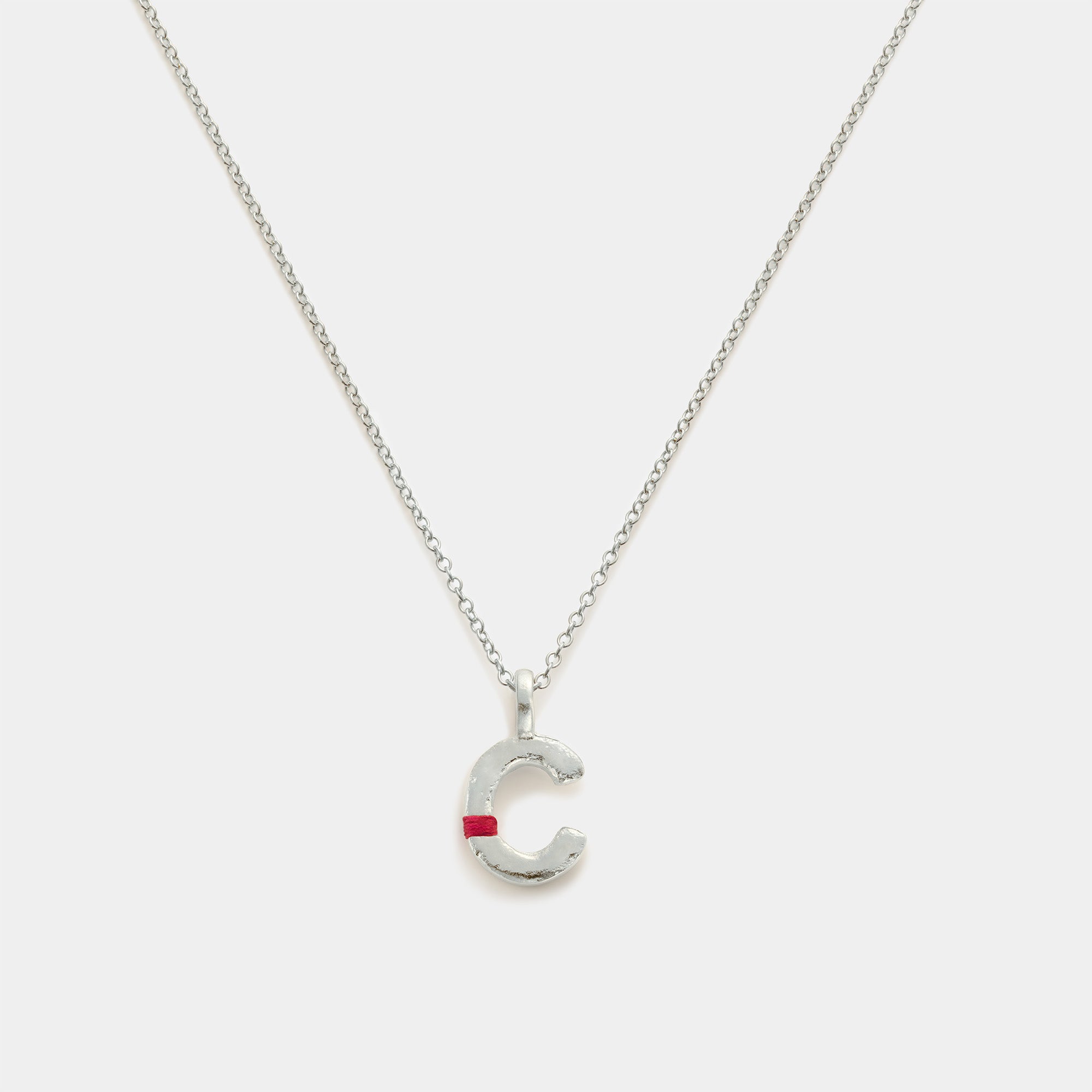 Silver necklace with a letter 'C' pendant on a white background