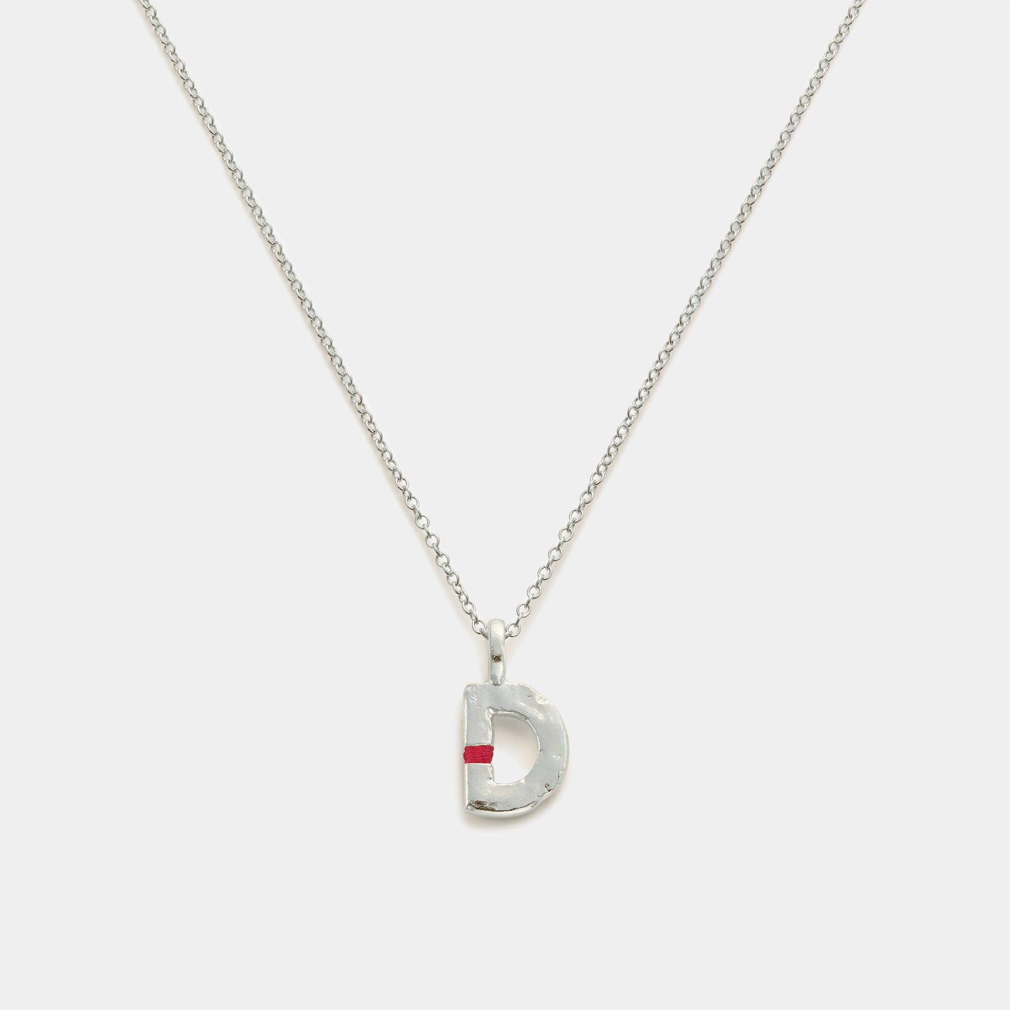 Silver necklace with a 'D' pendant on a white background