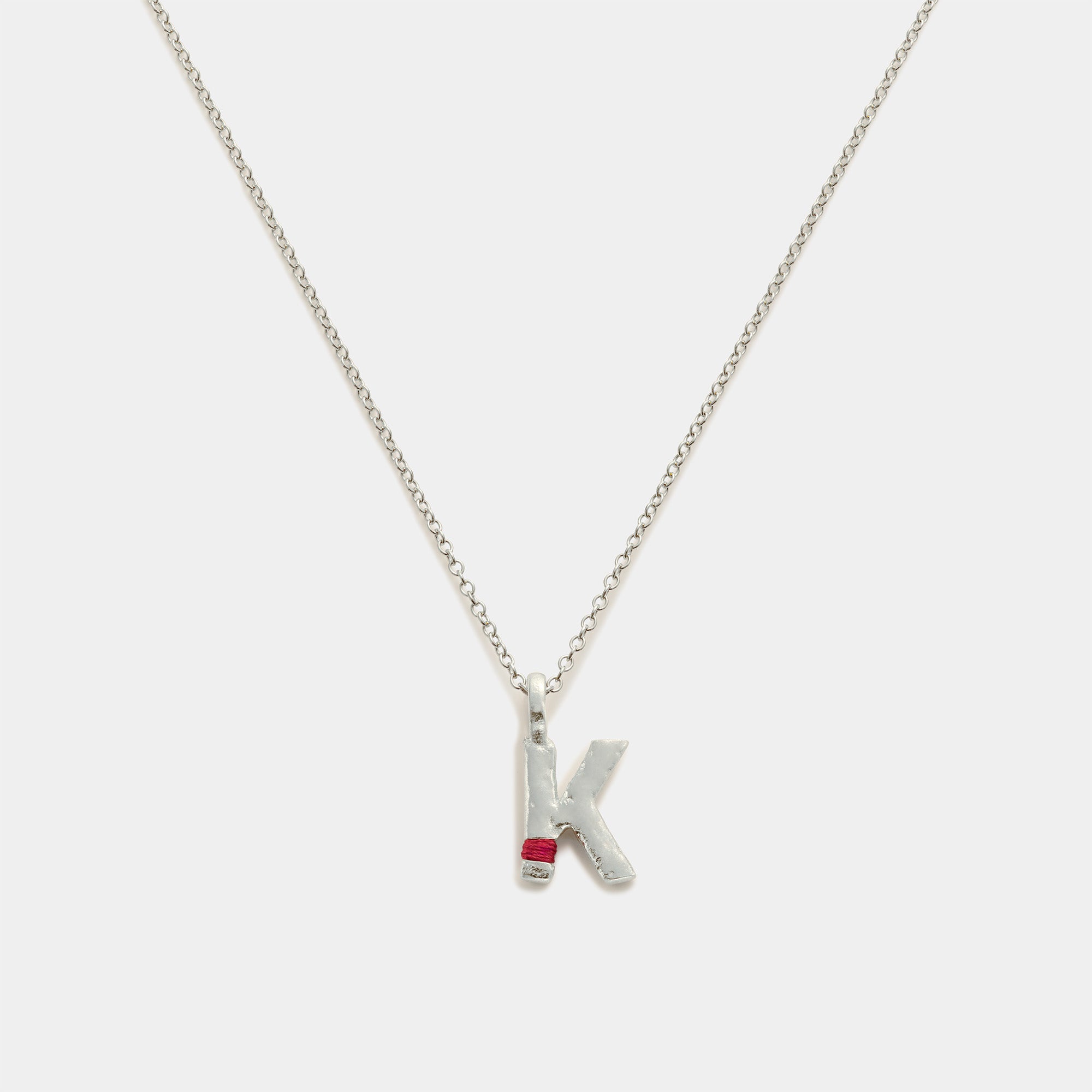 Silver necklace with a 'K' pendant on a white background